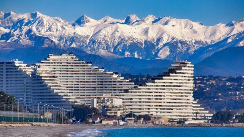 L'ensemble immobilier Marina Baie des Anges avec en arrière-plan les montagnes enneigées